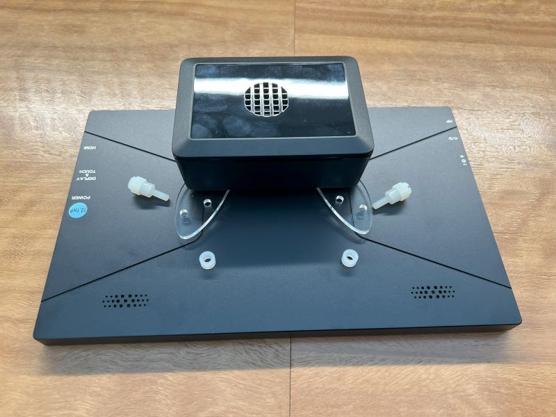 Image showing the VESA mount and the case sitting on top of the monitor with the nylon screws and spacers